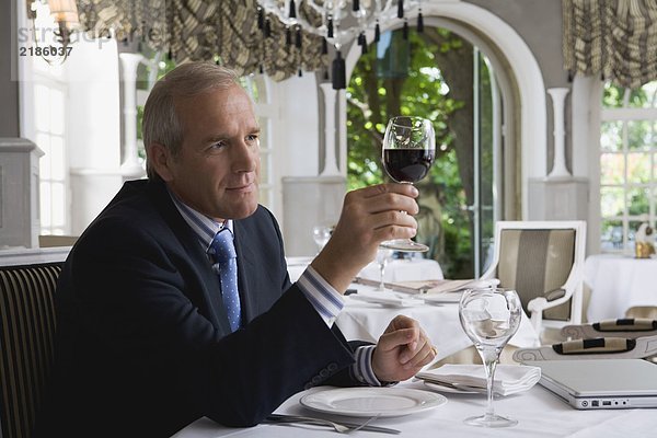 Geschäftsmann beim Blick auf ein Glas Wein in einem Restaurant