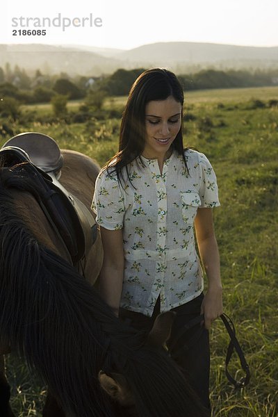 Frau stehend mit Pferd.