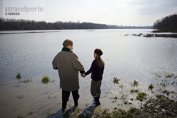 Großmutter und Enkelin (10-12) im Fluss stehend  Rückansicht