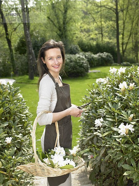 Eine Frau  die im Garten arbeitet und lächelt.