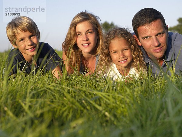 Familie  die auf einem Feld liegt.