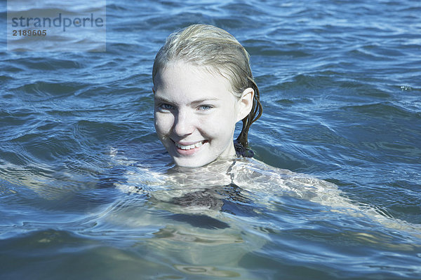 Junge Frau  die im Meer schwimmt.