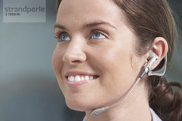 Close-Up Portrait der Geschäftsfrau mit Telefon-Headset / Ohrhörer.