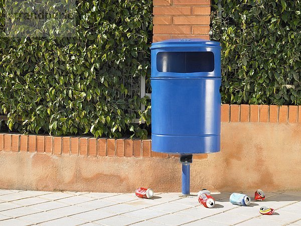 Öffentliche Mülltonne auf dem Bürgersteig  umgeben von ausrangierten Dosen  Alicante  Spanien