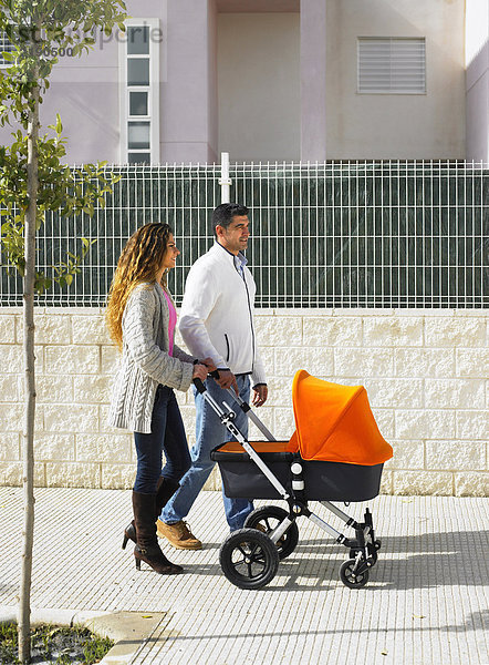 Paar Spaziergänge mit Kinderwagen auf dem Bürgersteig  Alicante  Spanien