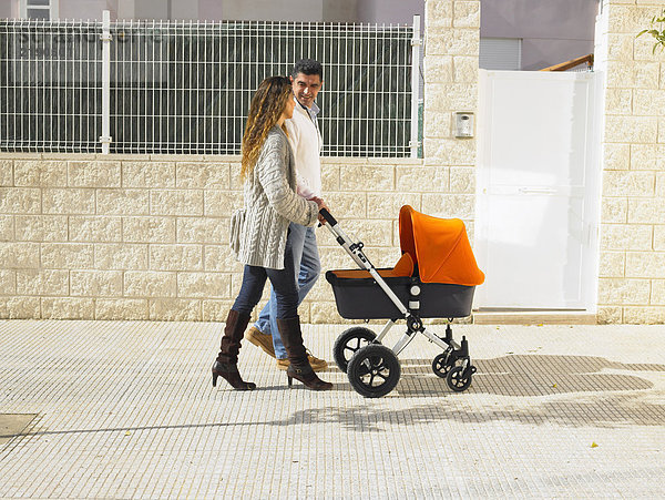 Paar Spaziergänge mit Kinderwagen auf dem Bürgersteig  Alicante  Spanien