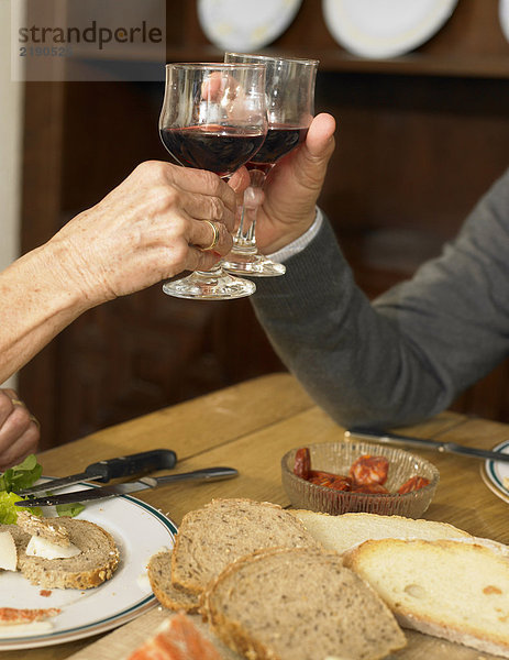 Seniorenpaar toastet mit Wein  Nahaufnahme