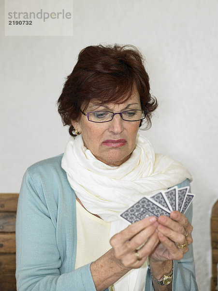 Seniorin spielt Karten  zieht Gesicht