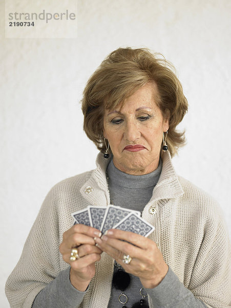 Seniorin spielt Karten  zieht Gesicht