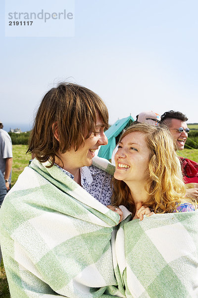 Paar in eine Decke gewickelt  die sich gegenseitig ansieht.