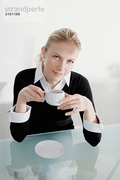 Eine Frau trinkt Kaffee.