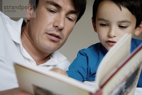 Porträt eines Vaters und eines Sohnes beim Lesen.