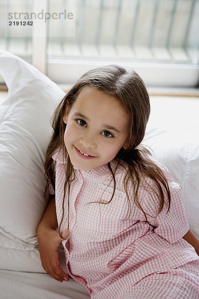 Porträt eines jungen Mädchens  das auf einem Bett liegt.