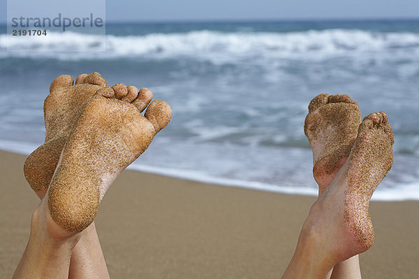 Paar Sandfüße am Strand.