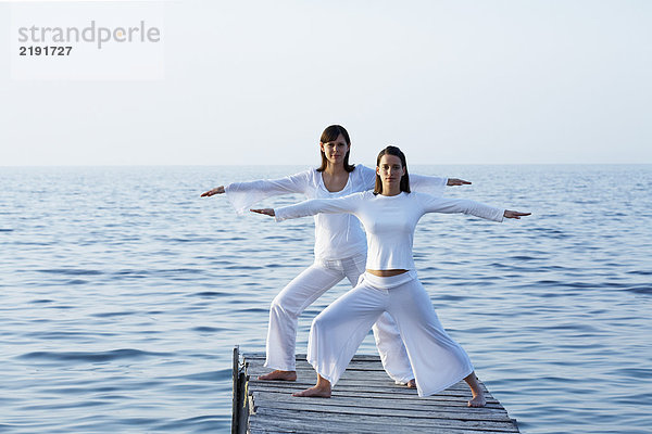 Zwei Frauen am Dock beim Yoga.