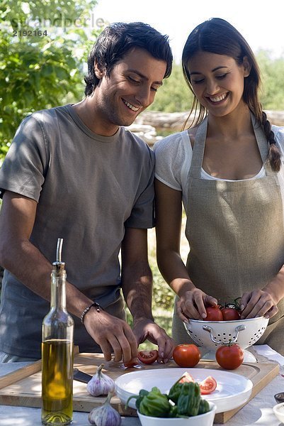 Junges Paar bereitet frische Tomaten zu