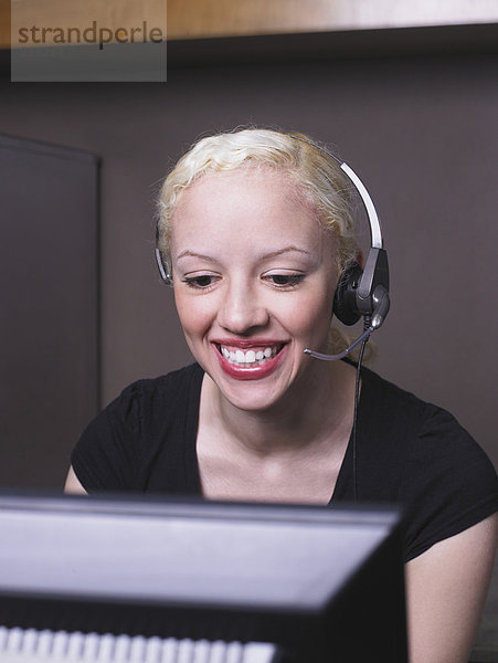 Frau lächelt auf Headset