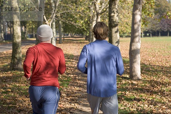 2 junge Männer beim Joggen von hinten.