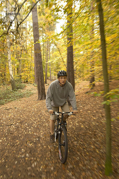 Herrenradfahren im Wald mit Helm  Herbst