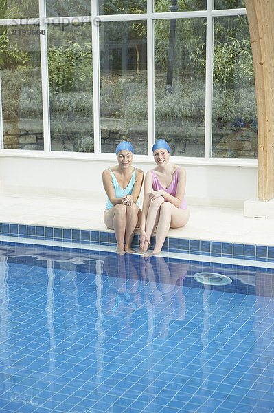 Zwei Frauen am Rande des Swimmingpools.