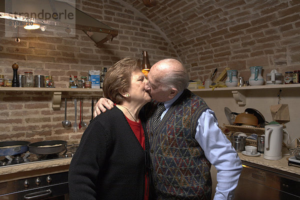 Seniorenpaar in der Küche  Küssen
