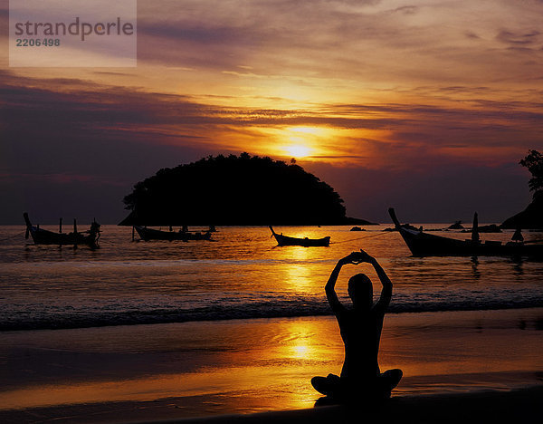 Thailand  Phuket  Kata Beach  Frau meditating at sunset