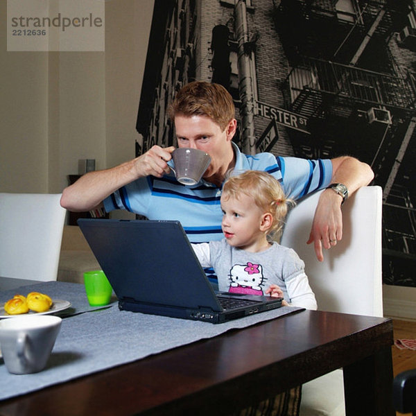 Mann und Tochter am Computer