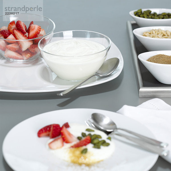 Joghurt und Erdbeeren in Glasschalen auf Teller  Nahaufnahme