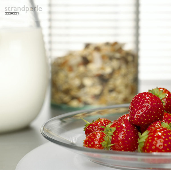 Strawberries on plate  cereals and milk in background