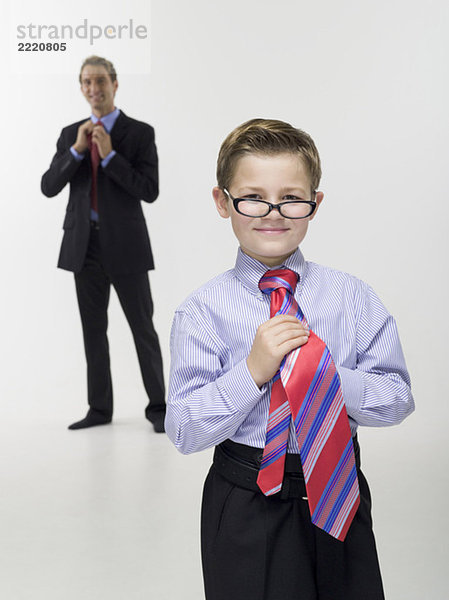Vater und Sohn (8-9) in Geschäftskleidung  Portrait