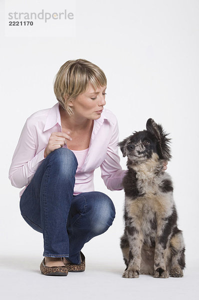 Junge Frau kauernd von Hund  Portrait