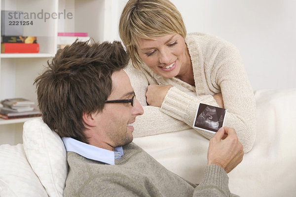 Couple  Man looking at ultrasound photos