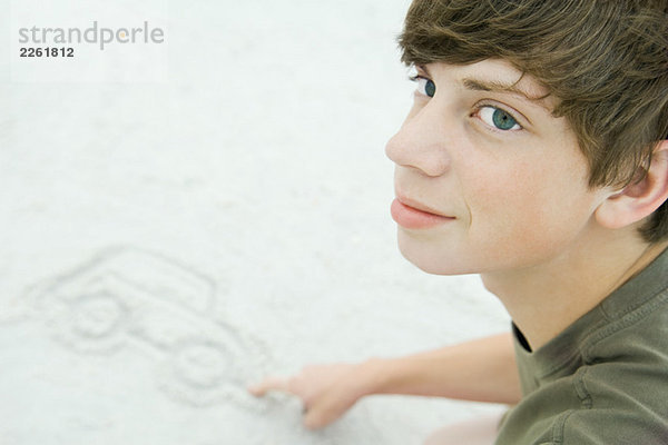 Teenager Junge Zeichnung Auto im Sand  Ausschnitt
