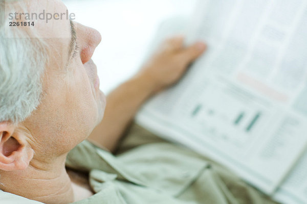 Älterer Mann beim Zeitungslesen  Hochwinkelansicht  beschnitten