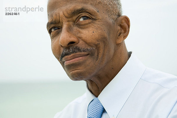 Älterer Mann schaut auf  lächelnd  abgeschnittenes Porträt
