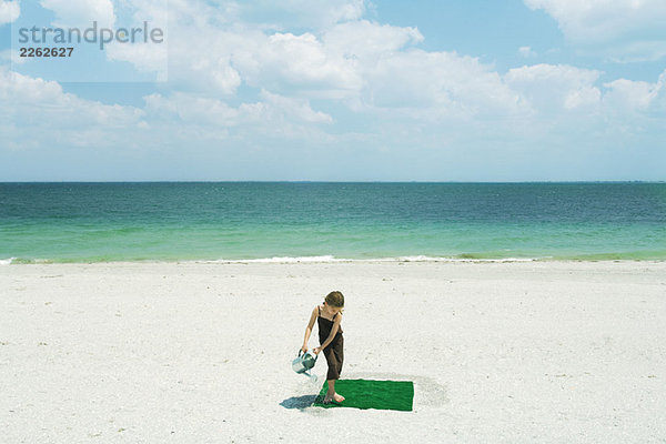 Mädchenbewässerungsplatz aus Kunstrasen am Strand  Hochwinkelansicht