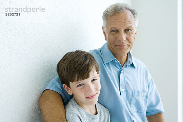 Großvater und Enkel lächeln gemeinsam vor der Kamera  Portrait