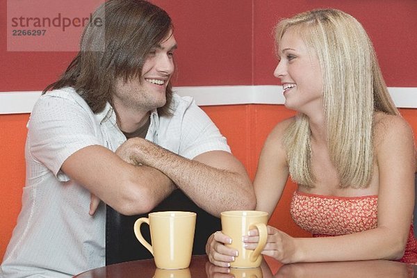 Blondes Mädchen und ein junger Mann im Café oder Restaurant