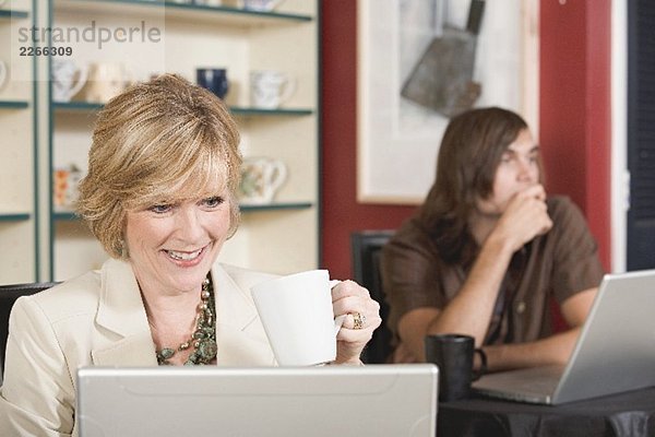 Frau mittleren Alters am Laptop in einem Café