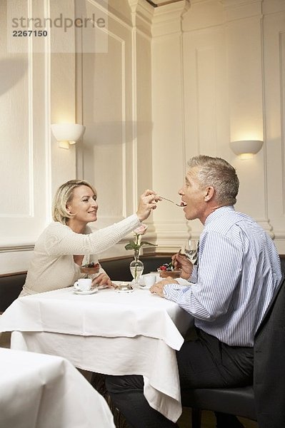 Paar mittleren Alters geniesst Dessert in einem Restaurant