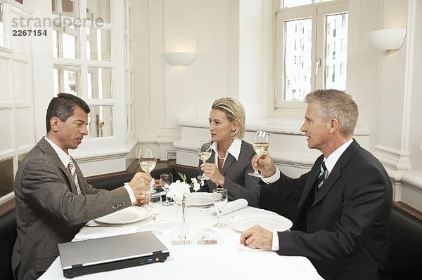 Drei Geschäftsleute bei gemeinsamen Essen