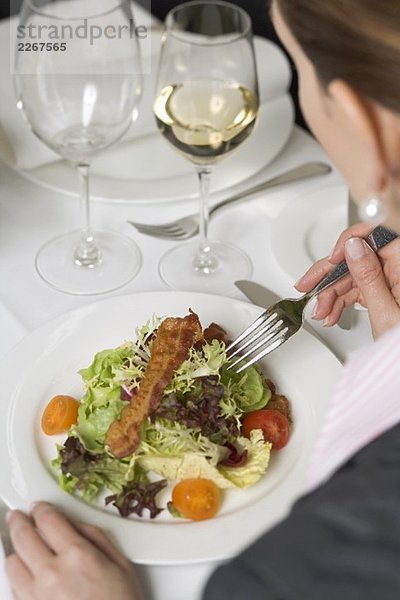 Frau isst Salat im Restaurant