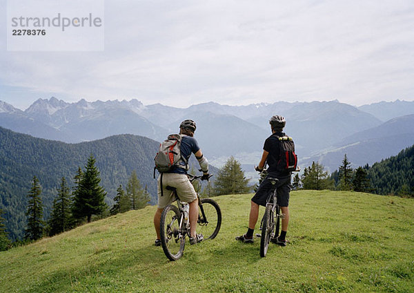 Zwei Radfahrer auf einem Hügel mit Blick auf die Aussicht