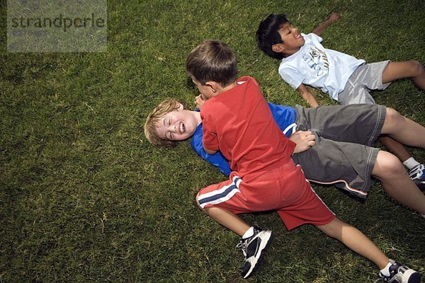 Boys Roughing Housing draußen auf dem Rasen