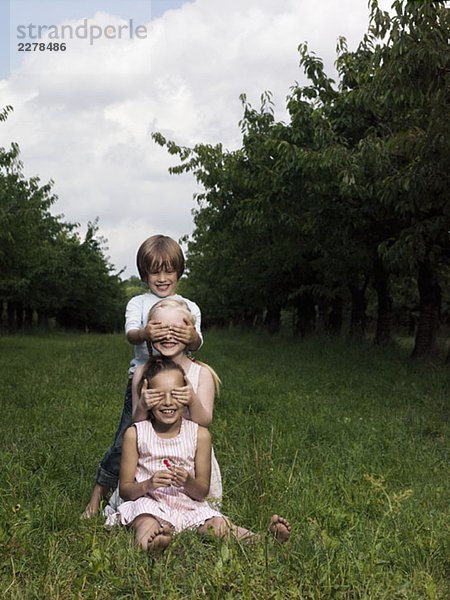 Drei Kinder spielen auf einem Feld