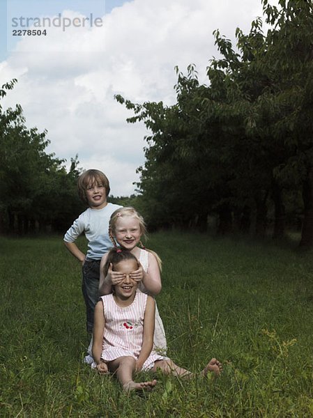 Drei Kinder im Garten