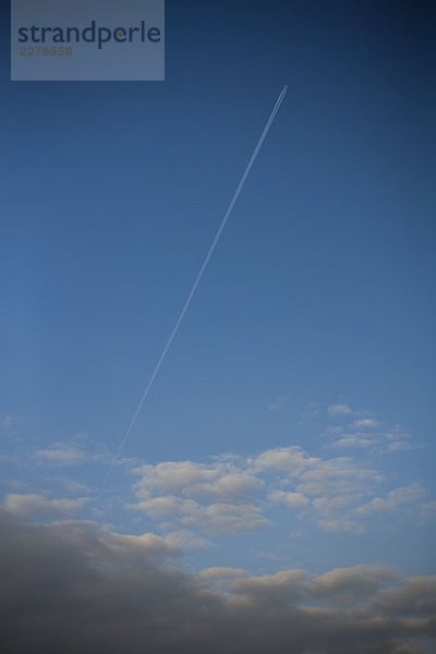 Ein Flugzeug am Himmel mit Kondensstreifen