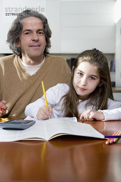 Ein Vater hilft seiner Tochter bei den Hausaufgaben.