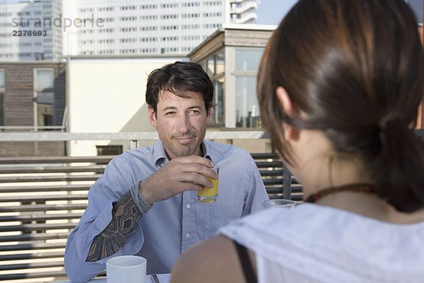 Ein Paar beim gemeinsamen Frühstück auf einer Dachterrasse