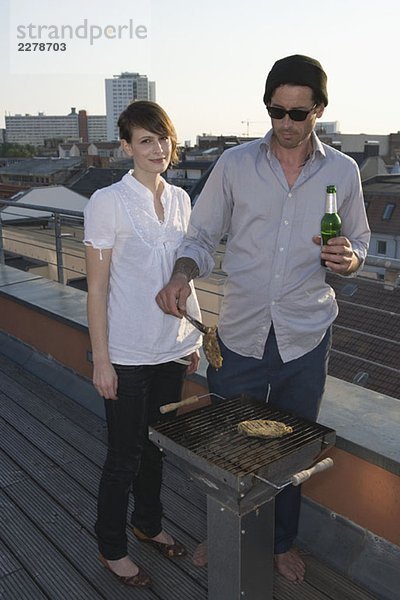 Zwei Personen beim Grillen auf der Dachterrasse